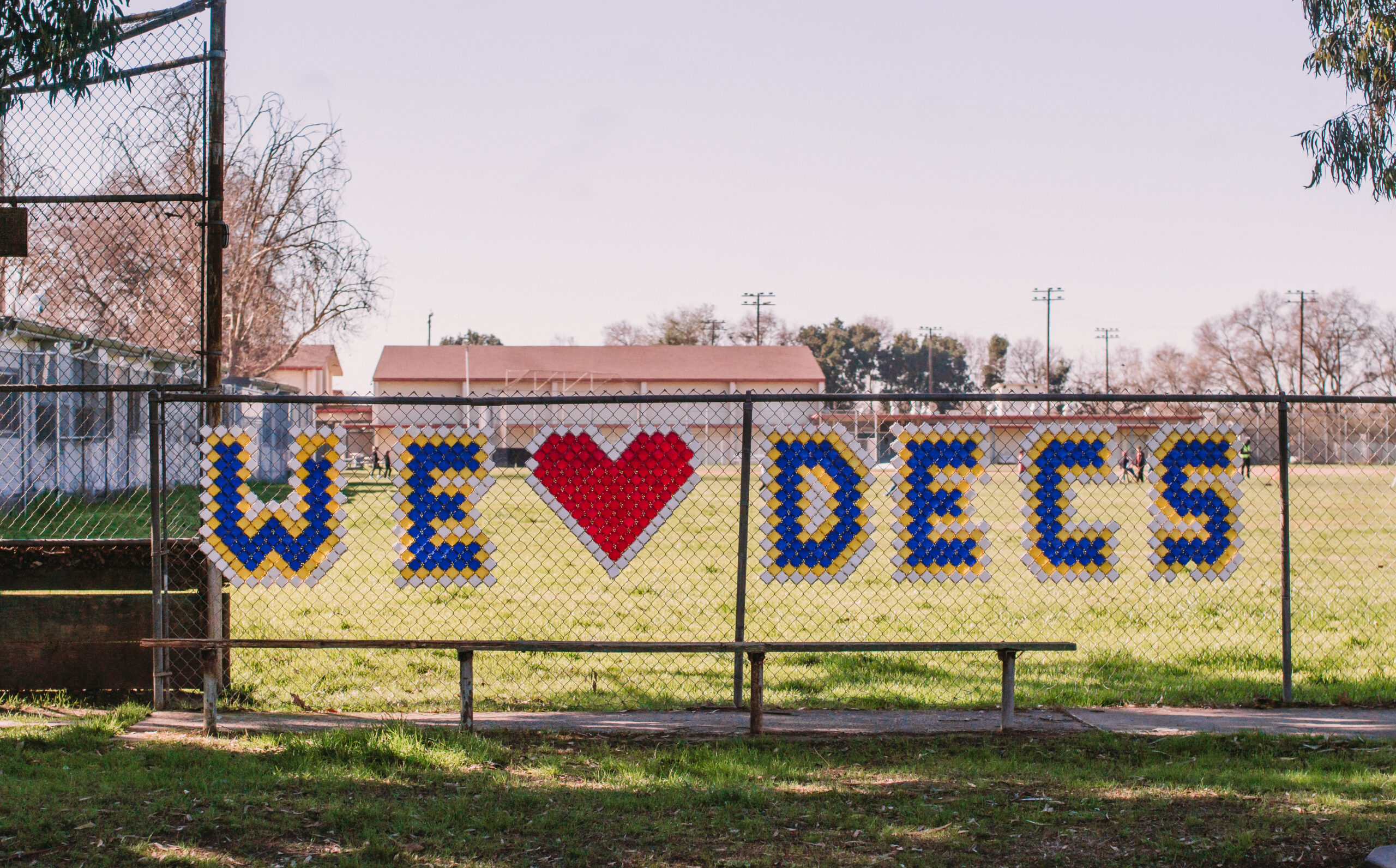 A We LOVE DECS banner in a fence in front of the schools ball field.